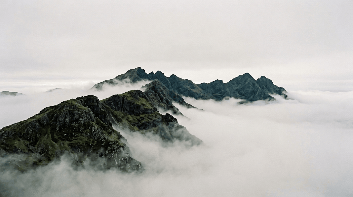 Misty mountain ridge fading into pale sky—calm editorial landscape study.