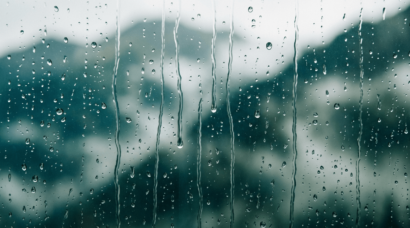 Rain on glass with soft blurred light—quiet interior mood study.
